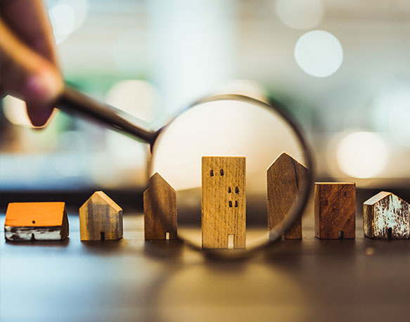 Wooden houses seen through a magnifying glass with blurred background.