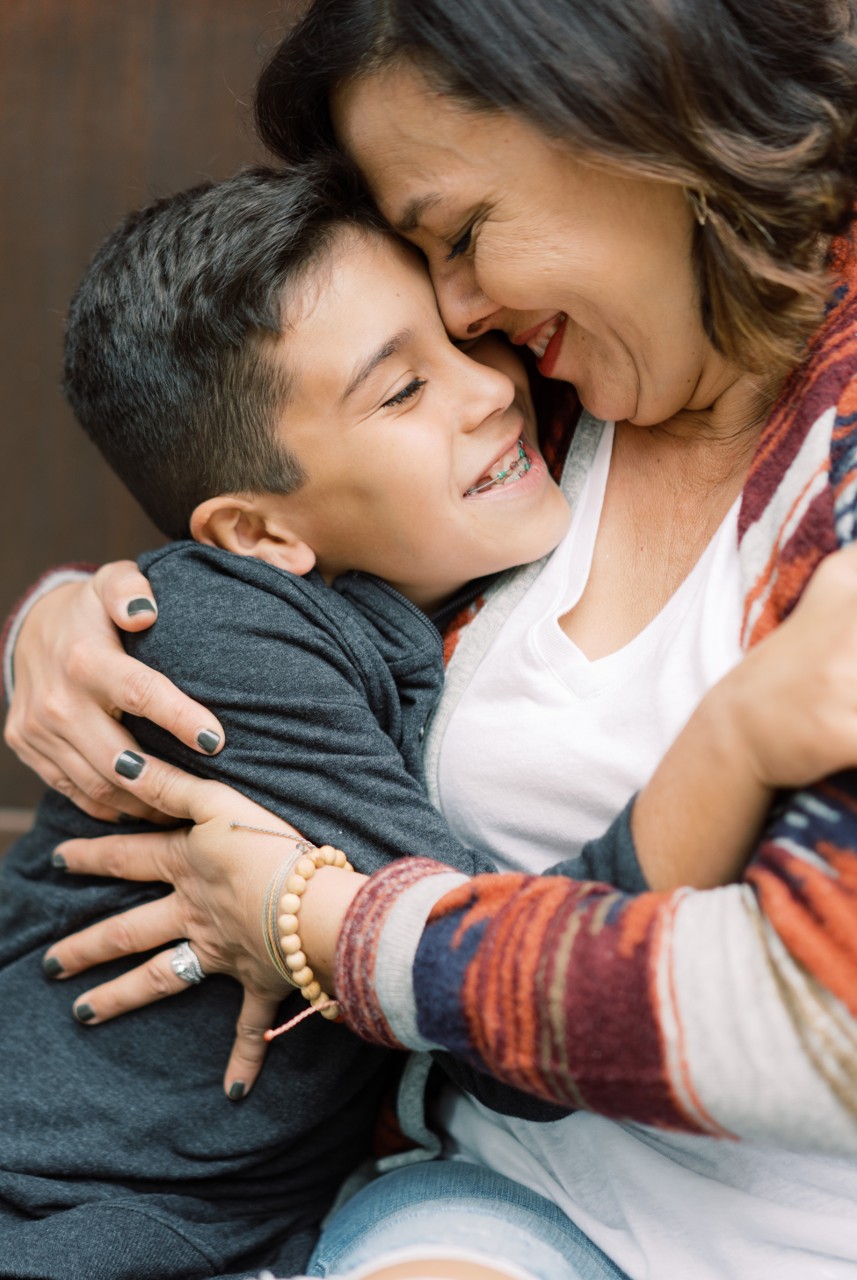 Woman with child smiling and embracing Woman with young child both are smiling and embracing